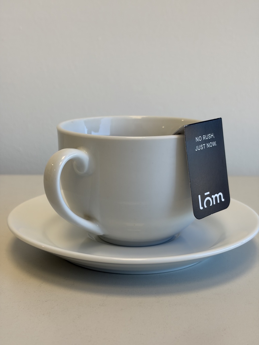 Detalle del sistema de anclaje LŌM sujeto al borde de una taza blanca